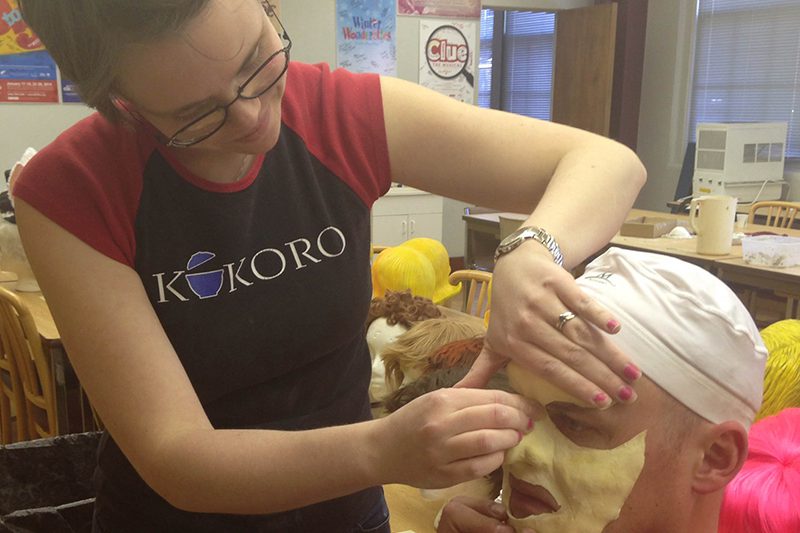 After making the foam mask of Shrek for the performance, Maeve fits it to Scott's face.